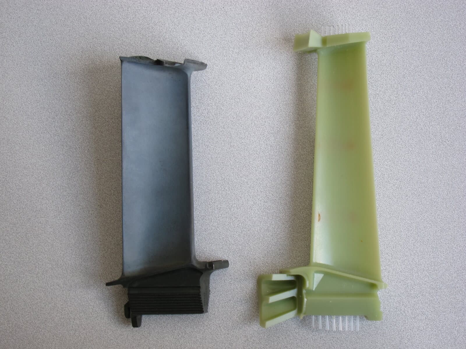 A nickel-alloy turbine blade next to the wax pattern used to cast parts of the same shape