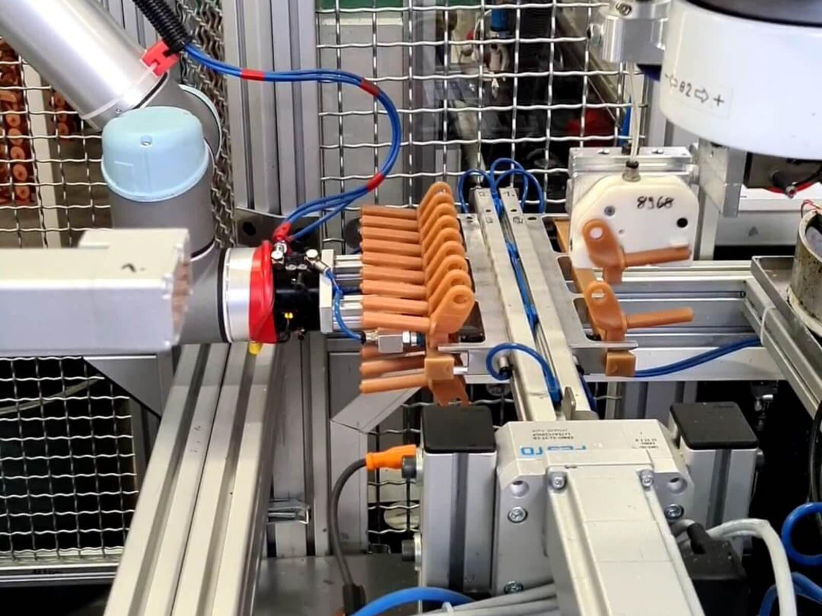 A robotic arm placing wax patterns onto a central sprue to build a pattern tree